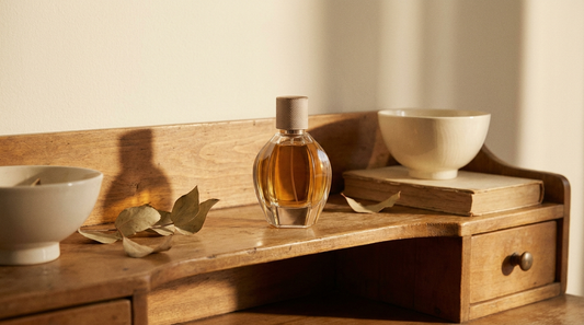 Amber perfume bottle on a wooden vanity shelf in warm afternoon light